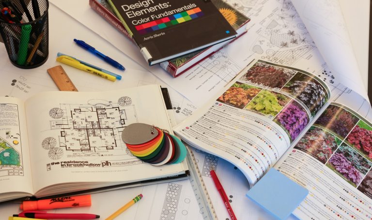 An assortment of landscape design books and materials open on a table.