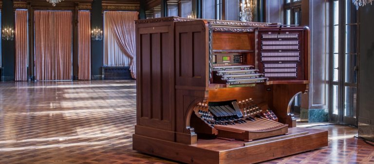 an organ console in a sunny ballroom