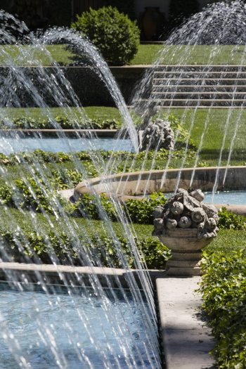 Fountains shoot into small arches across multiple pools adorned with descriptive stone flower bouquets