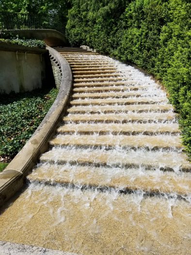 Water runs down a small set of tan stone stairs