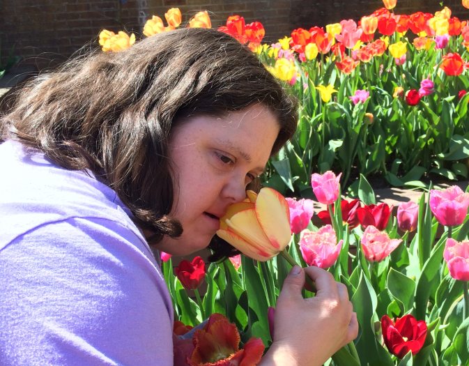 person smelling a yellow flower