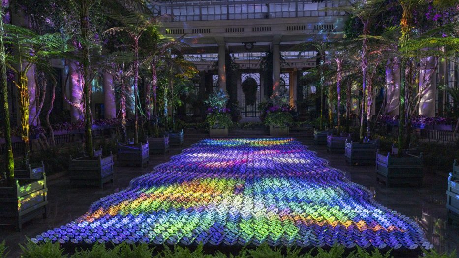 waves of reflective discs aligned on the Exhibition Hall floor glow with multi-colored light