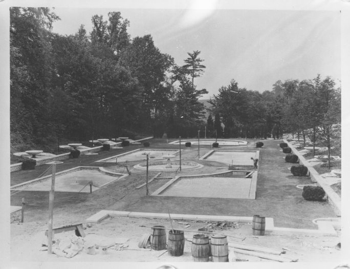 Black and white photo showing the construction of a large fountain garden