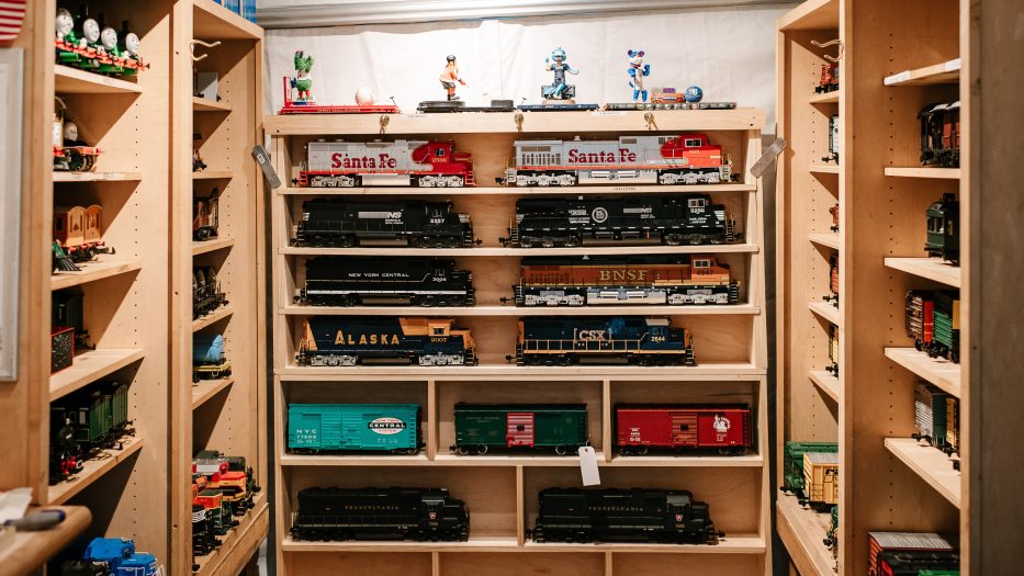 Inside view of storage shed housing shelf after shelf of miniature train engines and cars.