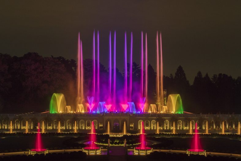 The Main Fountain Garden at Longwood with its fountains at night lit up in an array of colors.