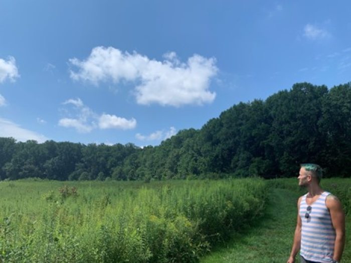 Professional Horticulture Student Kyle Prost looks out on the Meadow Garden on a clear summer day