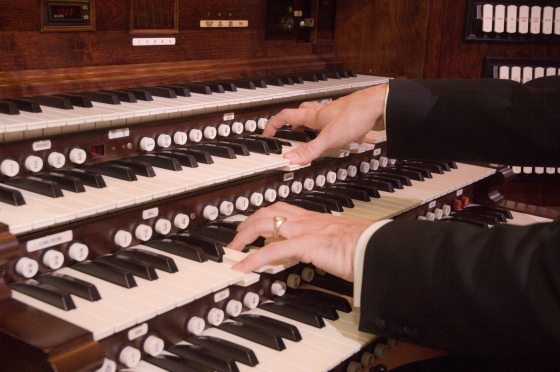 Close up of hands playing the organ