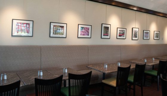a long row of tables against a wall hung with pictures