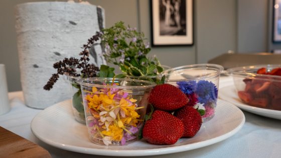 strawberries and herb blossoms on a white plate