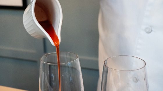 red liquid being poured into a wine glass