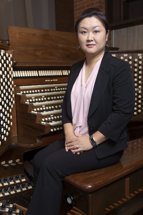 ahreum han facing the camera in front of an organ console