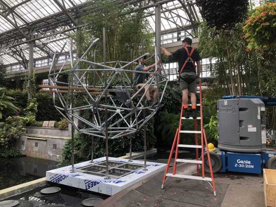 people assembling a metal dome