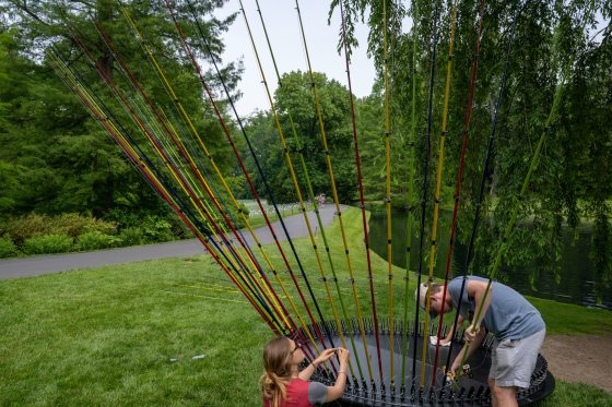 people assembling fishing rods into a large circular base