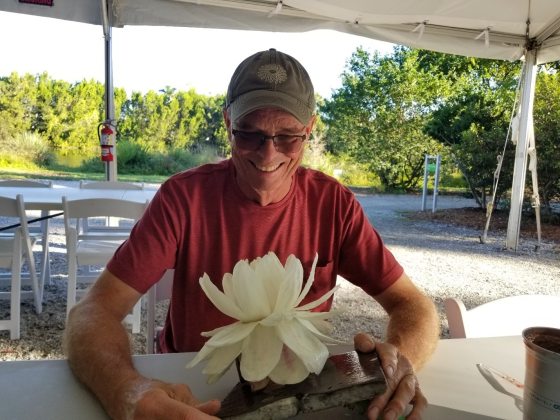 someone in a red shirt dissecting a white lotus flower