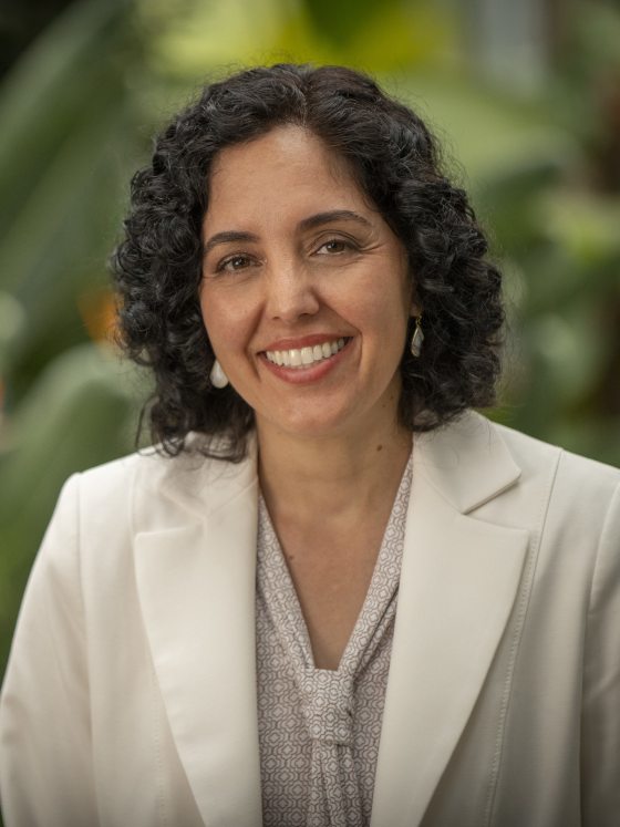 person in a white suit smiling at the camera