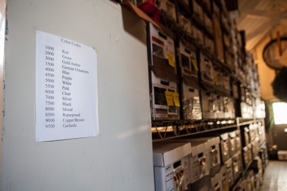 a wall with black text and boxes on shelving in the background