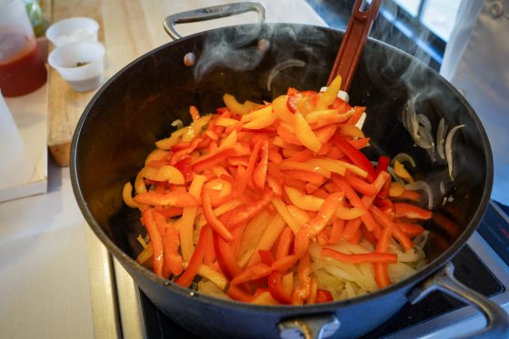 a pan full of sliced red, yellow, and orange peppers