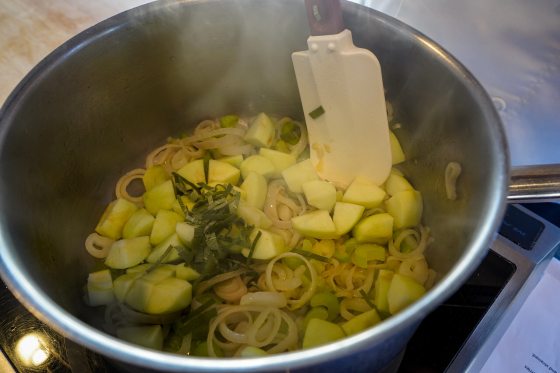 a pot on stove with apples and sage in it