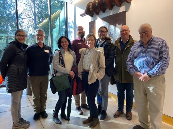 Eight people looking at the camera indoors