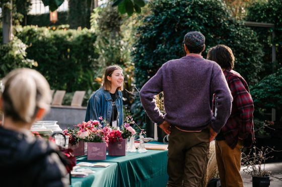 people standing at a table buying plants