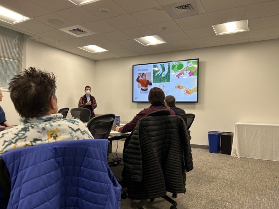 people  seated around a board room table looking at a presentation