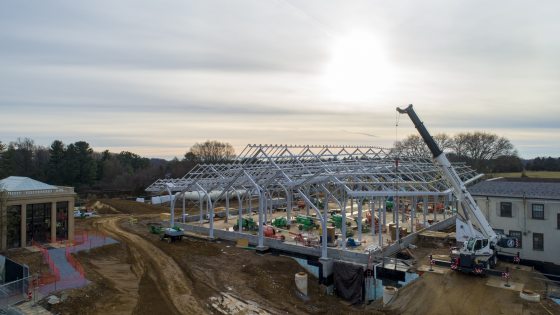 The sun shines through the clouds over the recently placed steel beams of the West Conservatory for Longwood Reimagined. 