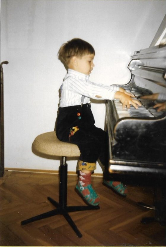 a young child playing on a piano