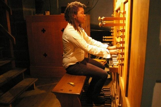 a person sitting at an organ console with their eyes closed and playing the keys