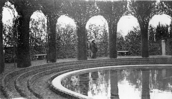a black and white image of alice du pont between arches made of plant material 