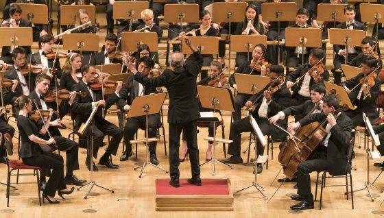 an orchestra playing on a wood stage