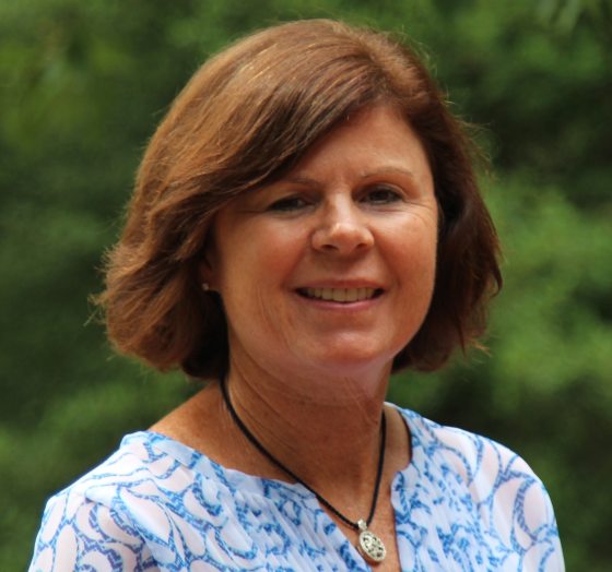 A headshot of a person in a floral shirt smiling at the camera.