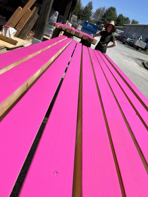 Slats of wood laying down painted in bright pink. 