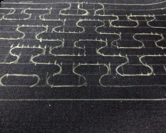 A Japanese pattern drawn in white onto black fabric.