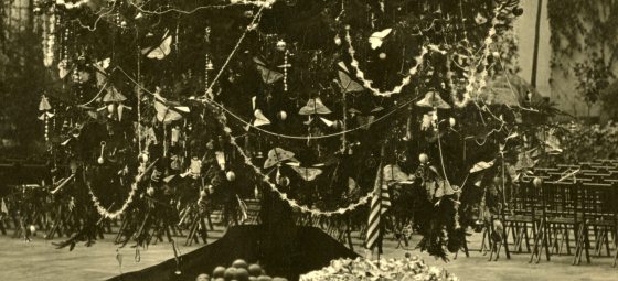 A black and white image of the bottom of a decorated Christmas tree.