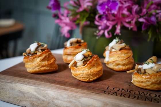 Pastries topped with chopped mushrooms and a white sauce.