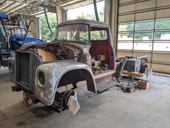A vintage truck being restored in a mechanic shop. 