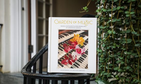 A book titled The Garden of Music resting on a railing inside a Conservatory.