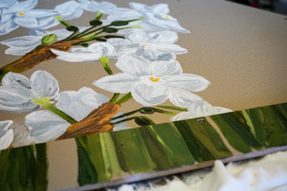 A painting of white flowers on a beige background.
