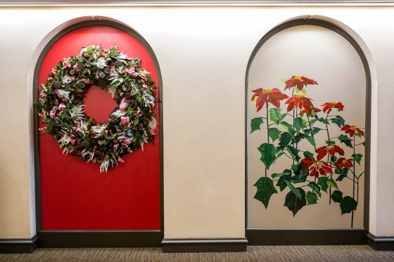 A mural inset in an arch of painted red poinsettia.