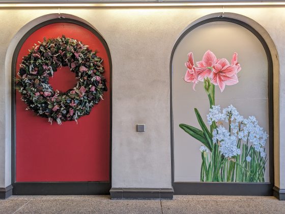 A mural inset in an arch of pink amaryllis and white flowers.