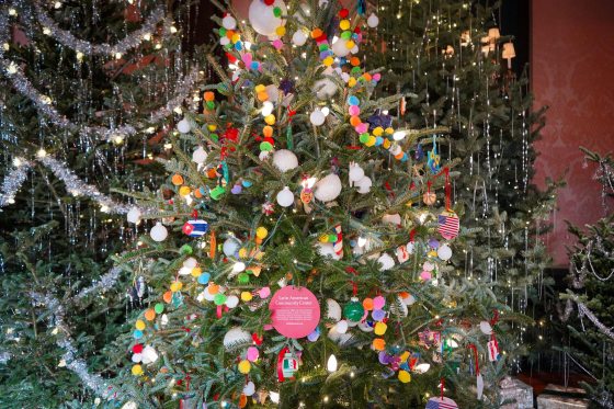 A Christmas tree decorated with ornaments made by young children.