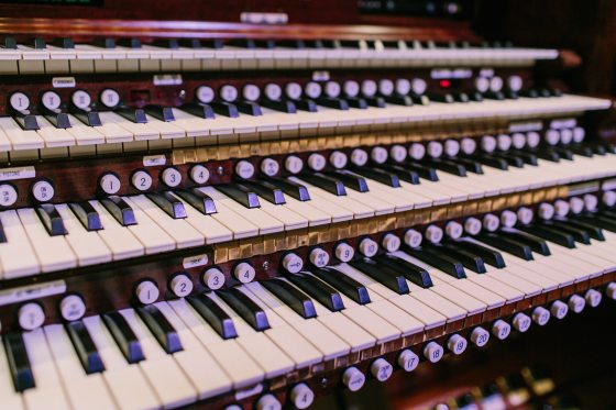 A close up image of an organ console and the keys.