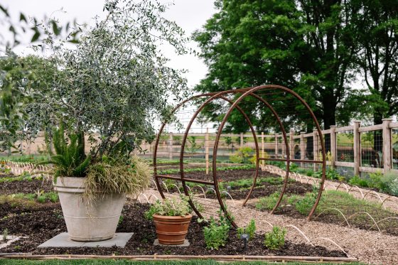 The Idea Garden at Longwood with spring plantings in the beds and a bronze circular archway in along the pathways.