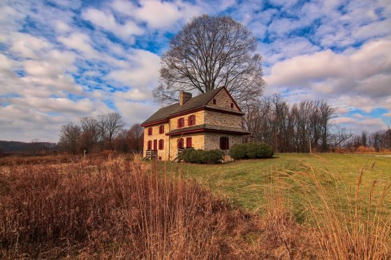 An old farmhouse situated in the Longwood Gardens Meadow Garden at dusk.