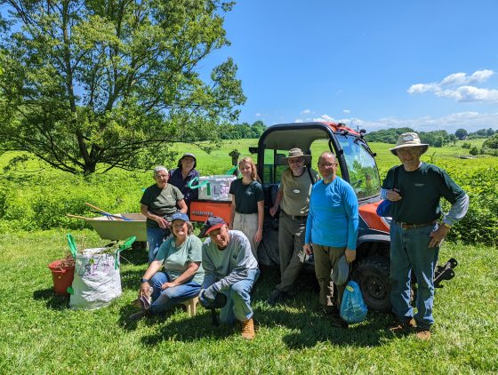 A group of people standing near a Meadow Garden after weeding.