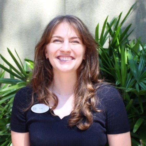 Portrait of person with long brown hair smiling at the camera.