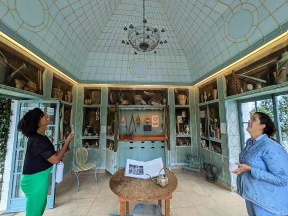 Two people in a historic house, looking up at the mint green ceiling.