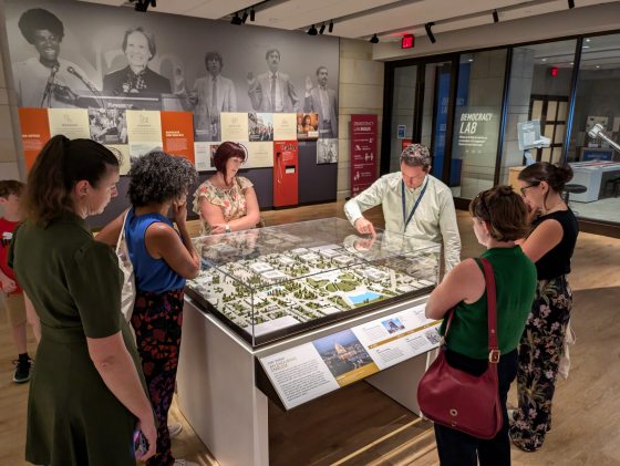 A group of people examining a model of the Capitol Grounds.
