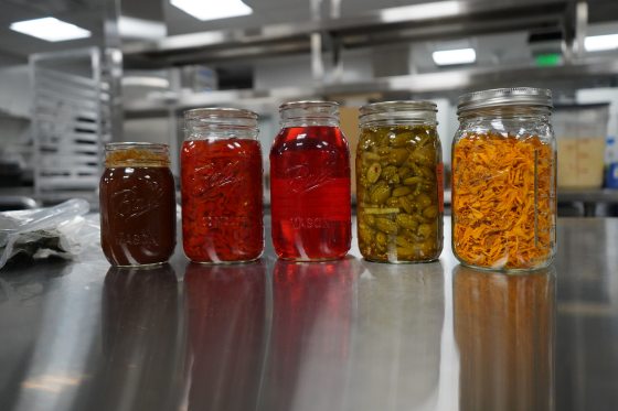 Five jars of canned spices and condiments.