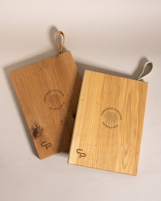 Two wood cutting boards stamped with the words Longwood Gardens Reimagined.